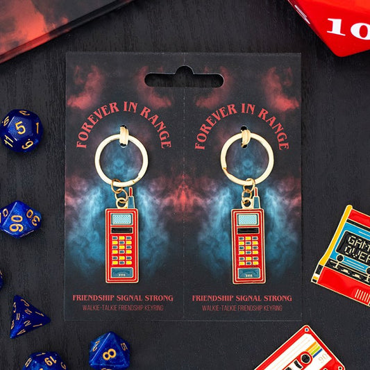 Keychain packaging with 'Forever in Range' text and keychains on a dark background with dice and cassette tapes.
