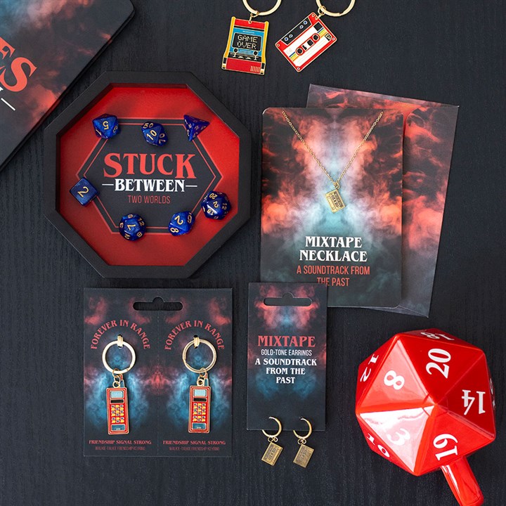 Collection of themed merchandise including dice, keychains, and jewelry on a dark background