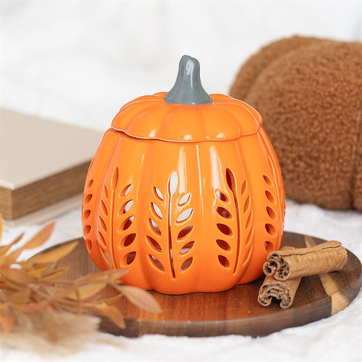 Orange ceramic pumpkin-shaped lantern with a gray top on a wooden surface.