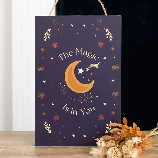 Decorative sign with moon and stars design on a dark background