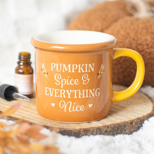 Orange mug with 'Pumpkin Spice & Everything Nice' text on a wooden surface with a bottle and spoon in the background.