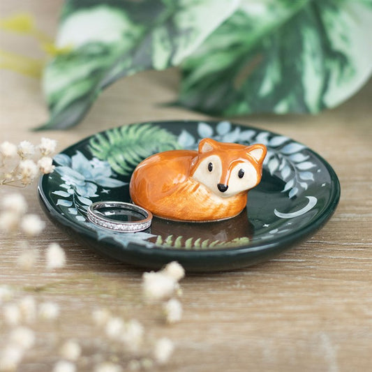 Fox-shaped ring holder on a decorative plate with floral and leaf patterns