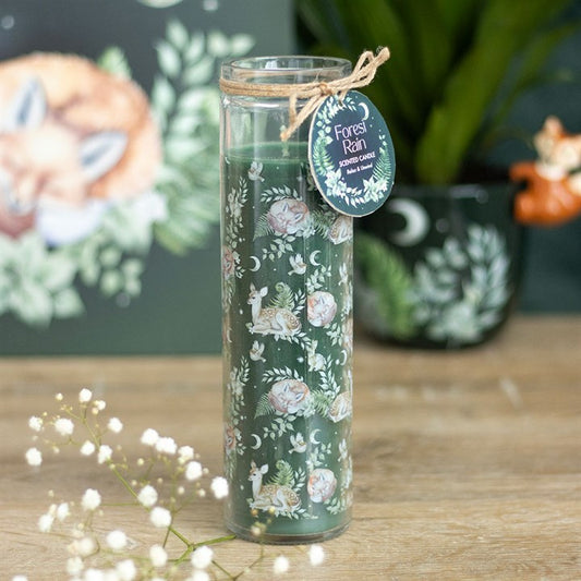 Decorative candle with nature-themed design on a wooden surface