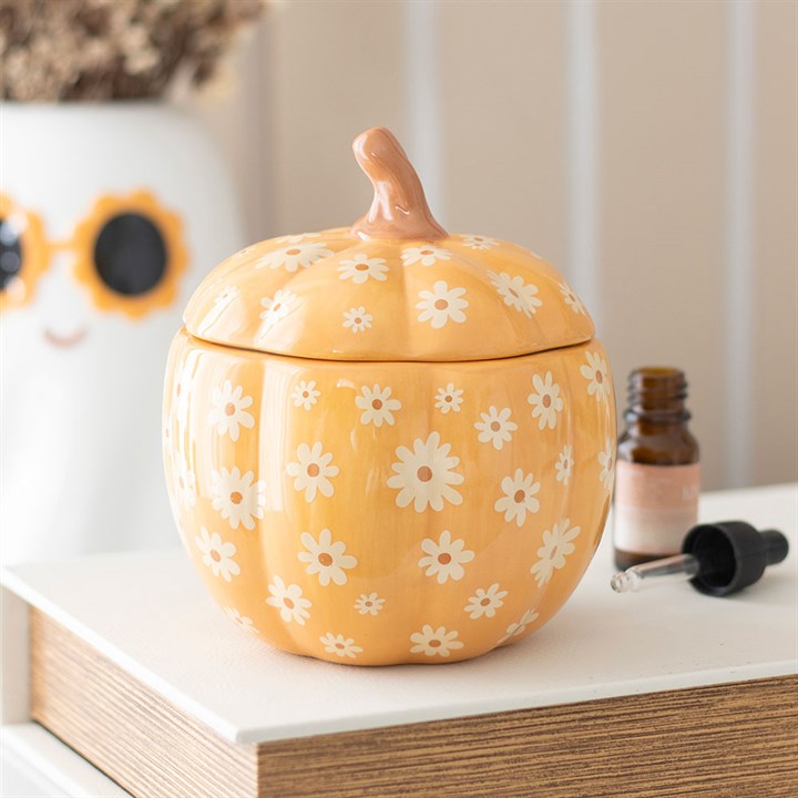 Yellow pumpkin-shaped container with floral patterns on a surface
